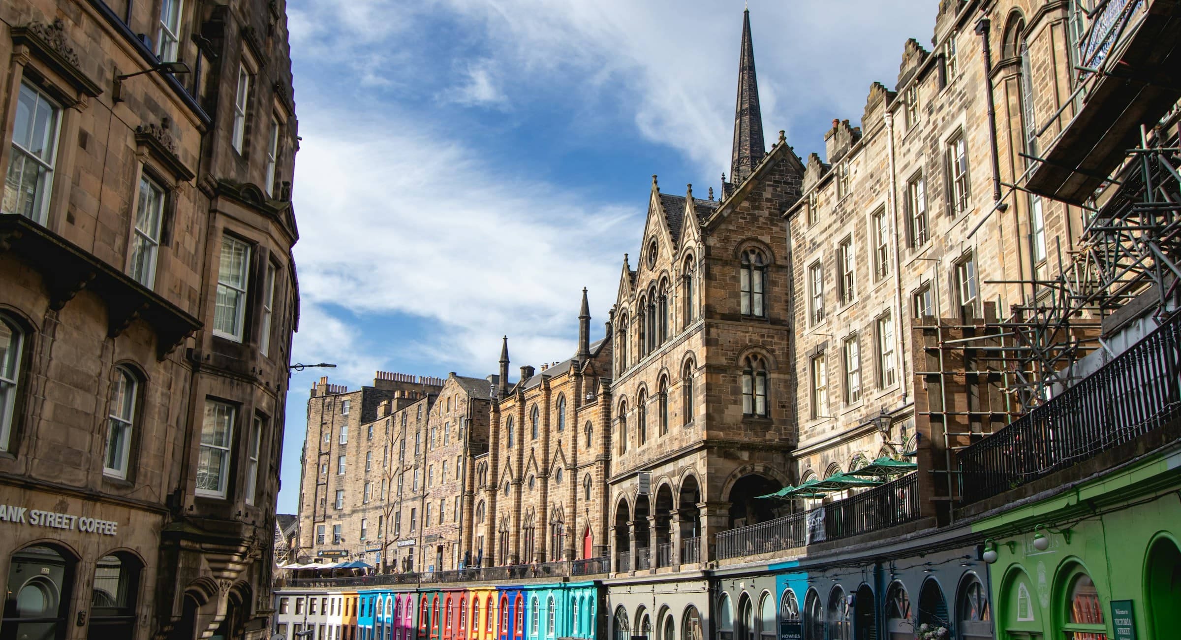 A lively historic street lined with colorful independent shopfronts